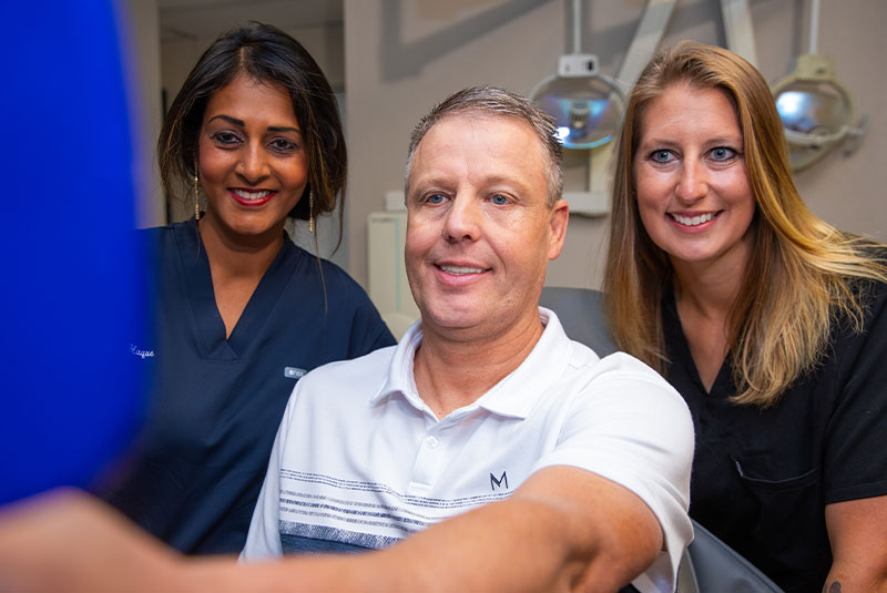 Patient and doctor smiling into mirror