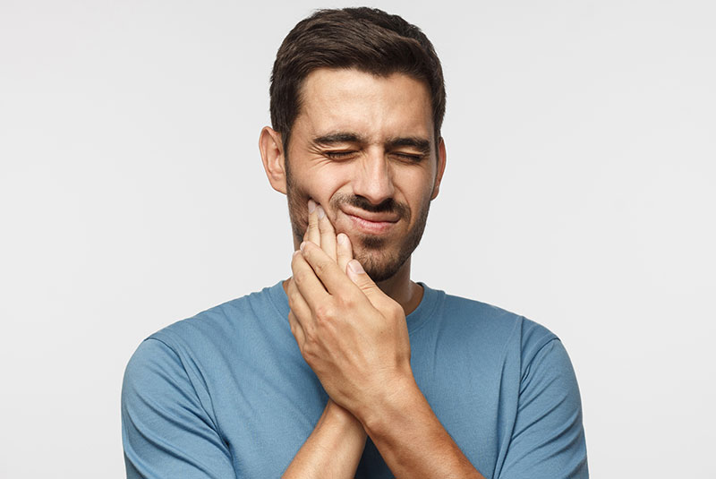 Man holding mouth in pain
