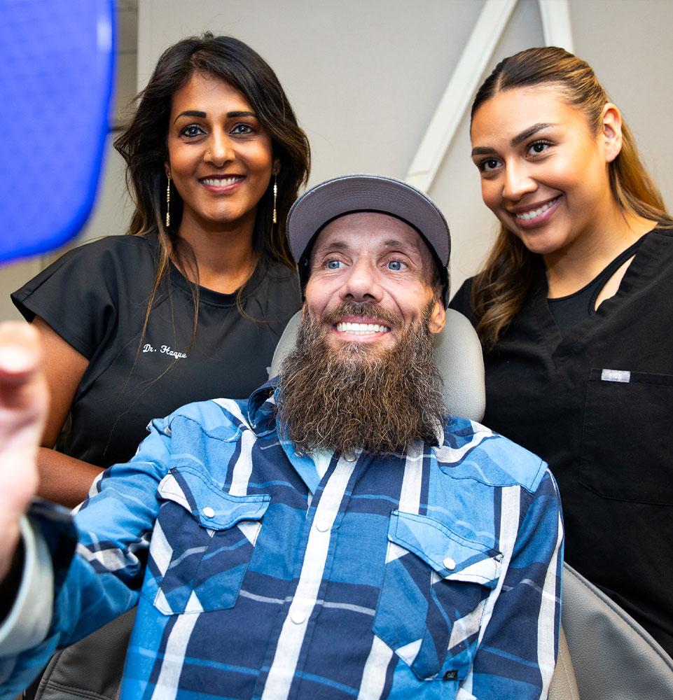 Patient smiling into mirror after dental implant Procedure