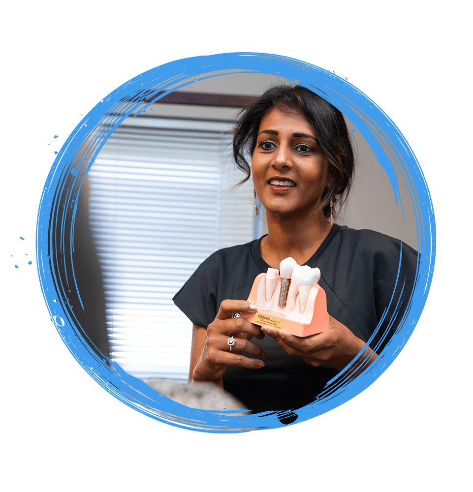 Doctor showing Patient model of dental implants