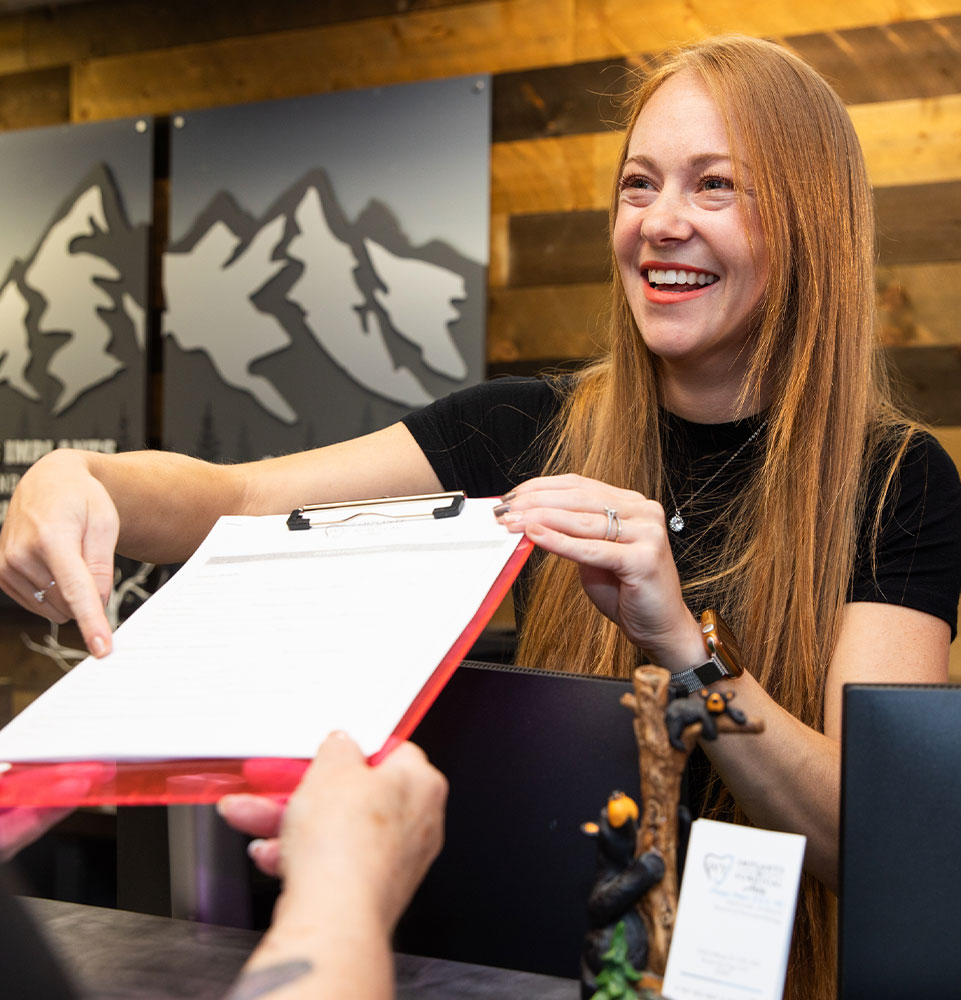 team member handing Patient a insurance form